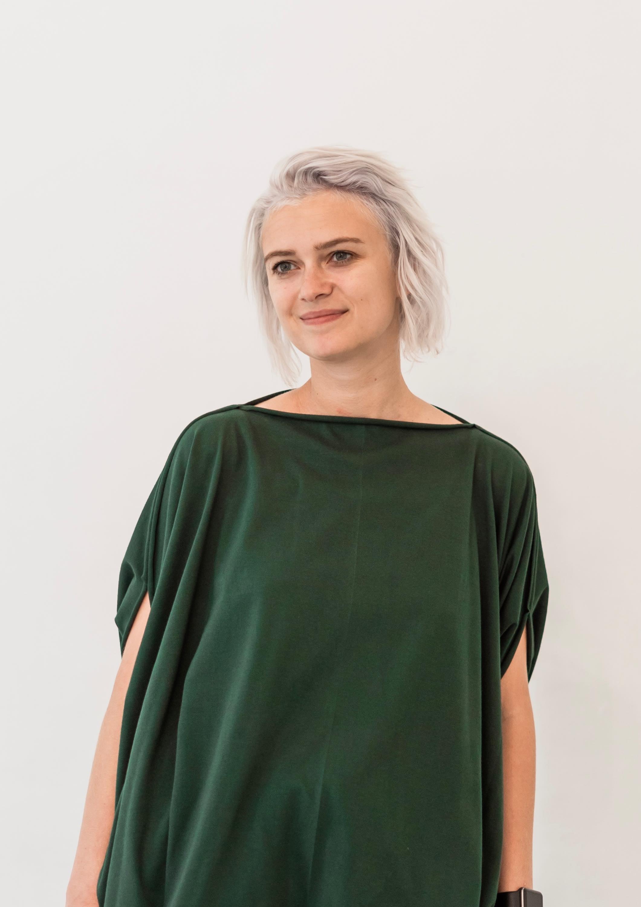 Multifunctional deep green fluid jersey, made from 100% organic cotton. Can be worn as a blouse, vest or poncho. With two sided adjustable drawn strings.