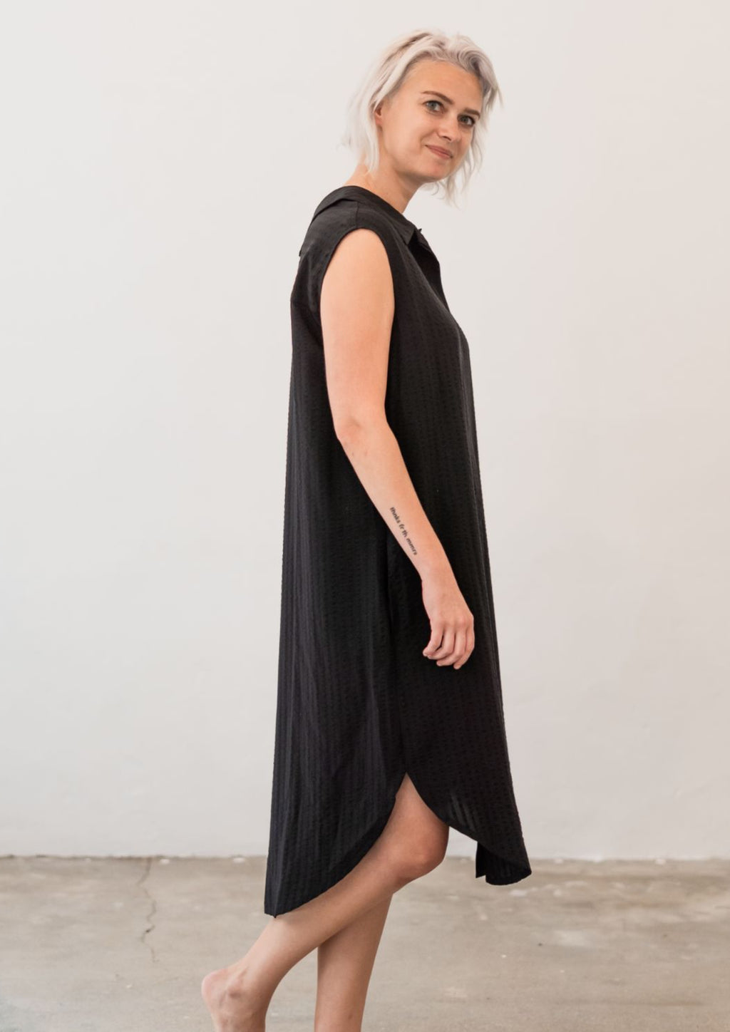 Reversible soft dress. Can be worn as a long shirt, dress or tunic. With two collars and buttoned full-length opening. Textured fabric in black.