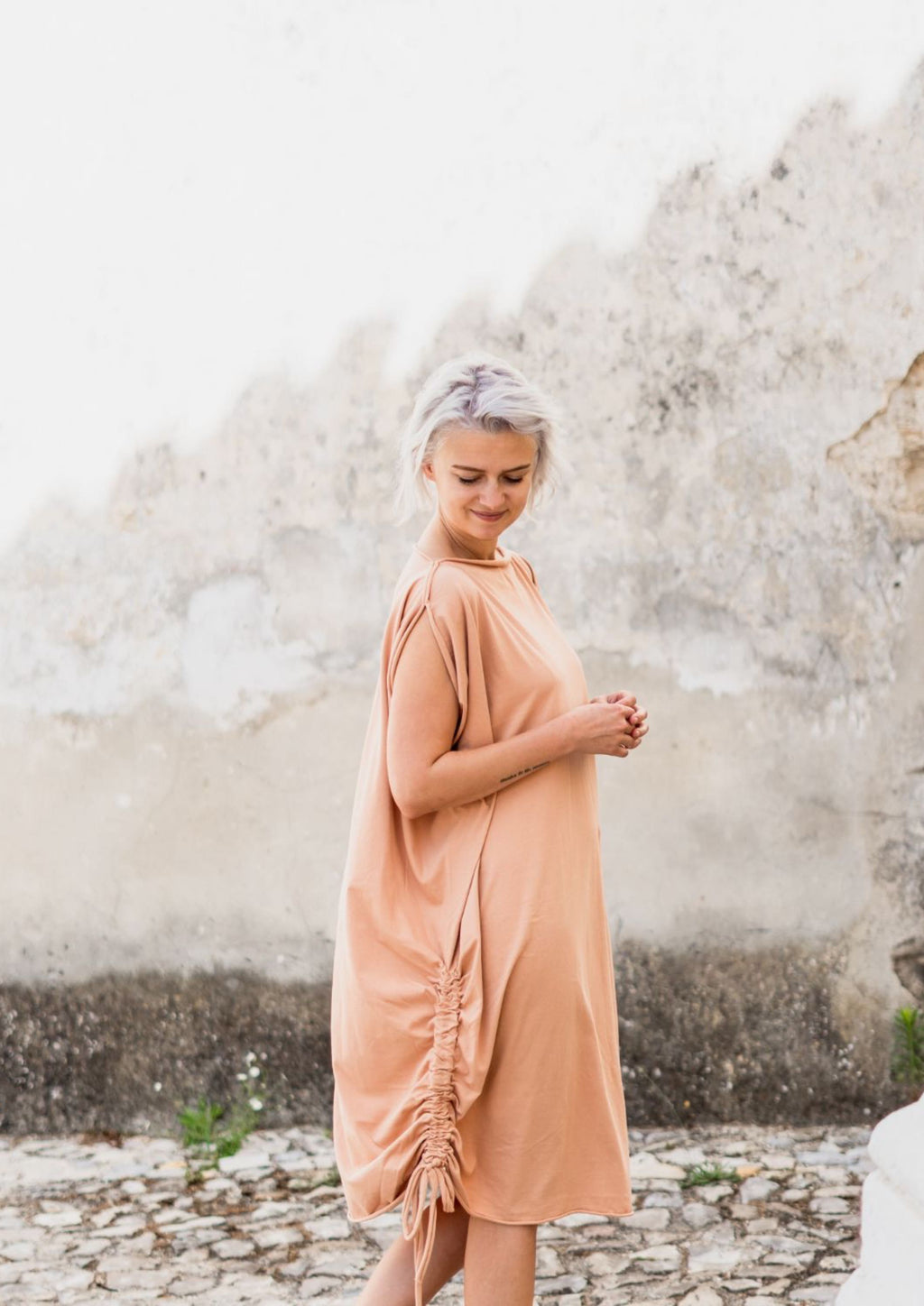 Multifunctional flowing and soft jersey. Can be worn as a dress, vest or poncho. With adjustable drawstring to regulate the shape. 100% organic cotton. Nude colour.